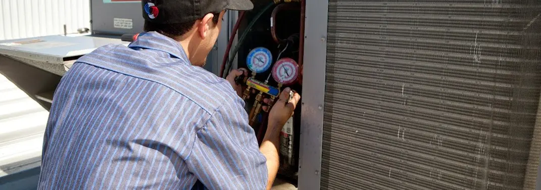 HVAC technician servicing a condenser unit in Brandon