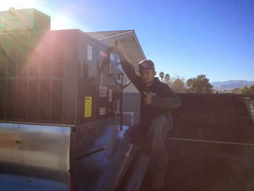 HVAC technician performing Boiler Repair on a rooftop unit in Brandon